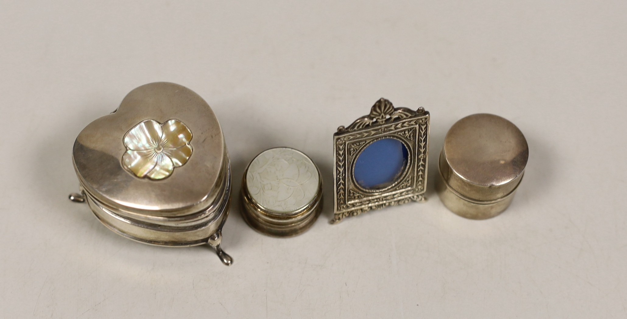 A George V silver heart shape trinket box, Saunders & Shepherd, Birmingham, 1910, 45mm, a ring box, a pill box and a small photograph frame.